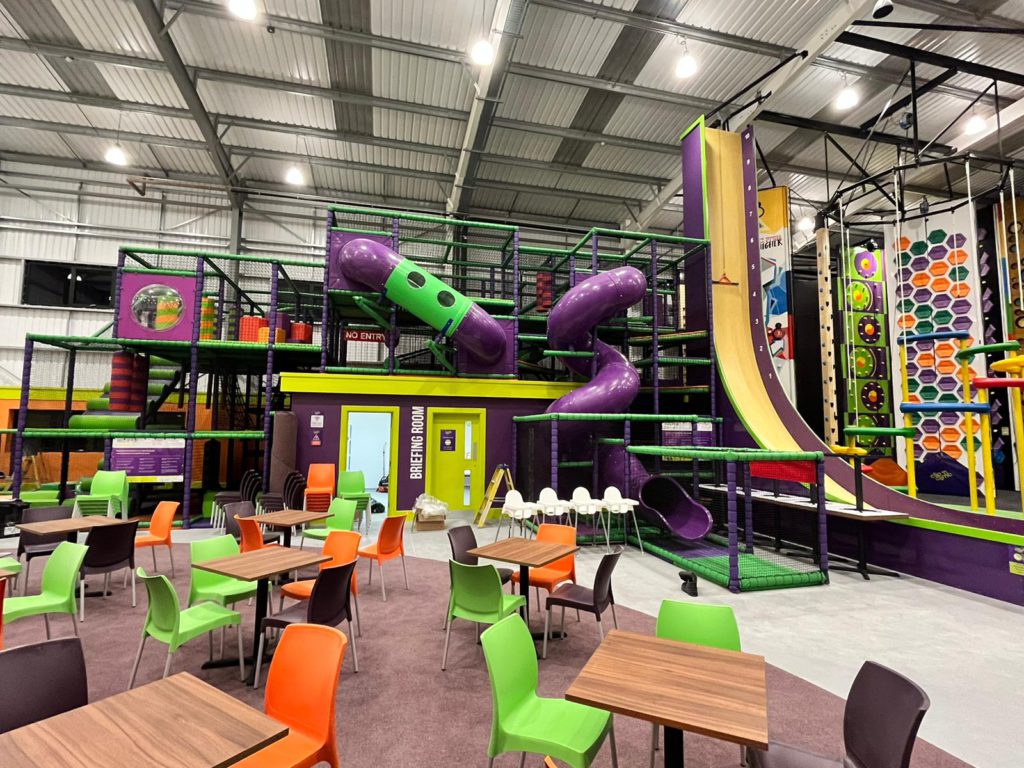 A brightly coloured Clip 'n Climb centre with fun climbing challenges, soft play, and tables and chairs at South Ridge Cafe